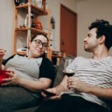 Doi oameni care merg pe o stradă a orașului, la distanță unul de altul, în lumina serii